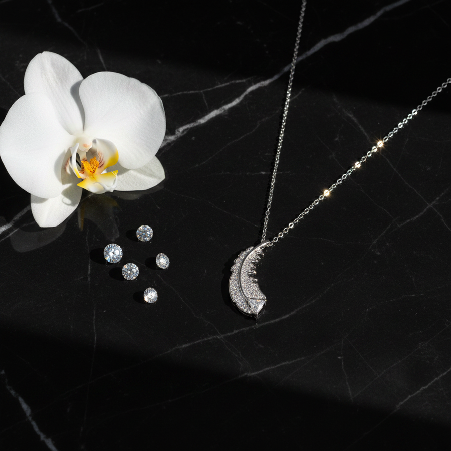 925 Sterling Silver CZ Diamond Feather Necklace black marble flat lay with orchid